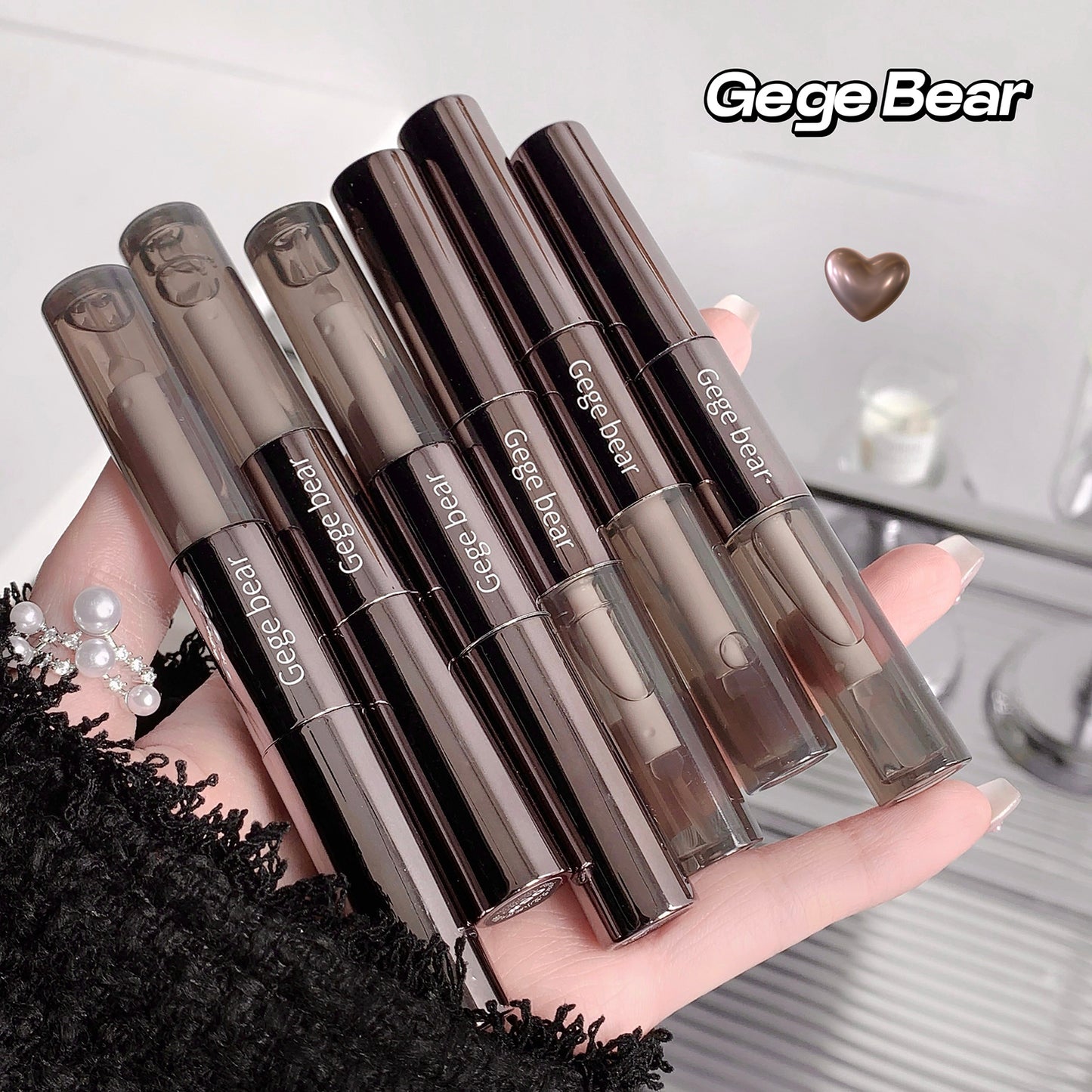 Set of GegeBear lip products held in a hand with a blurred background