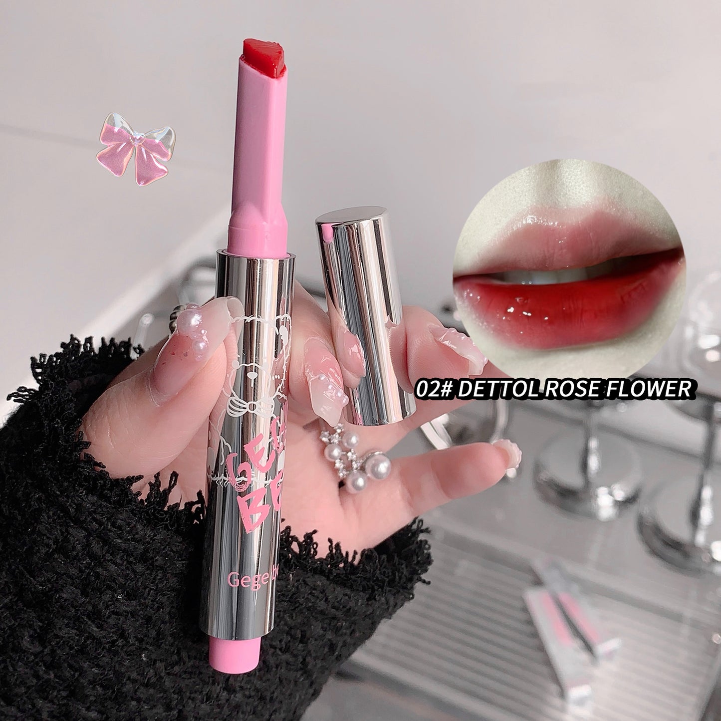 Pink lipstick held by a hand with a blurred background