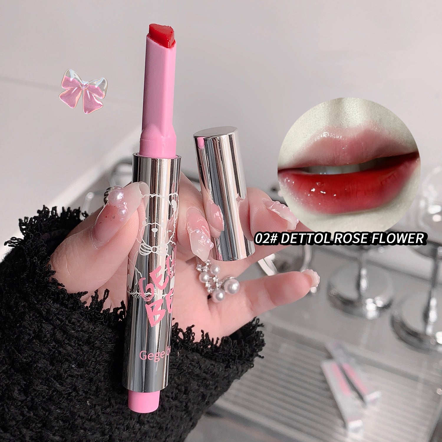 Pink lipstick held by a hand with a blurred background