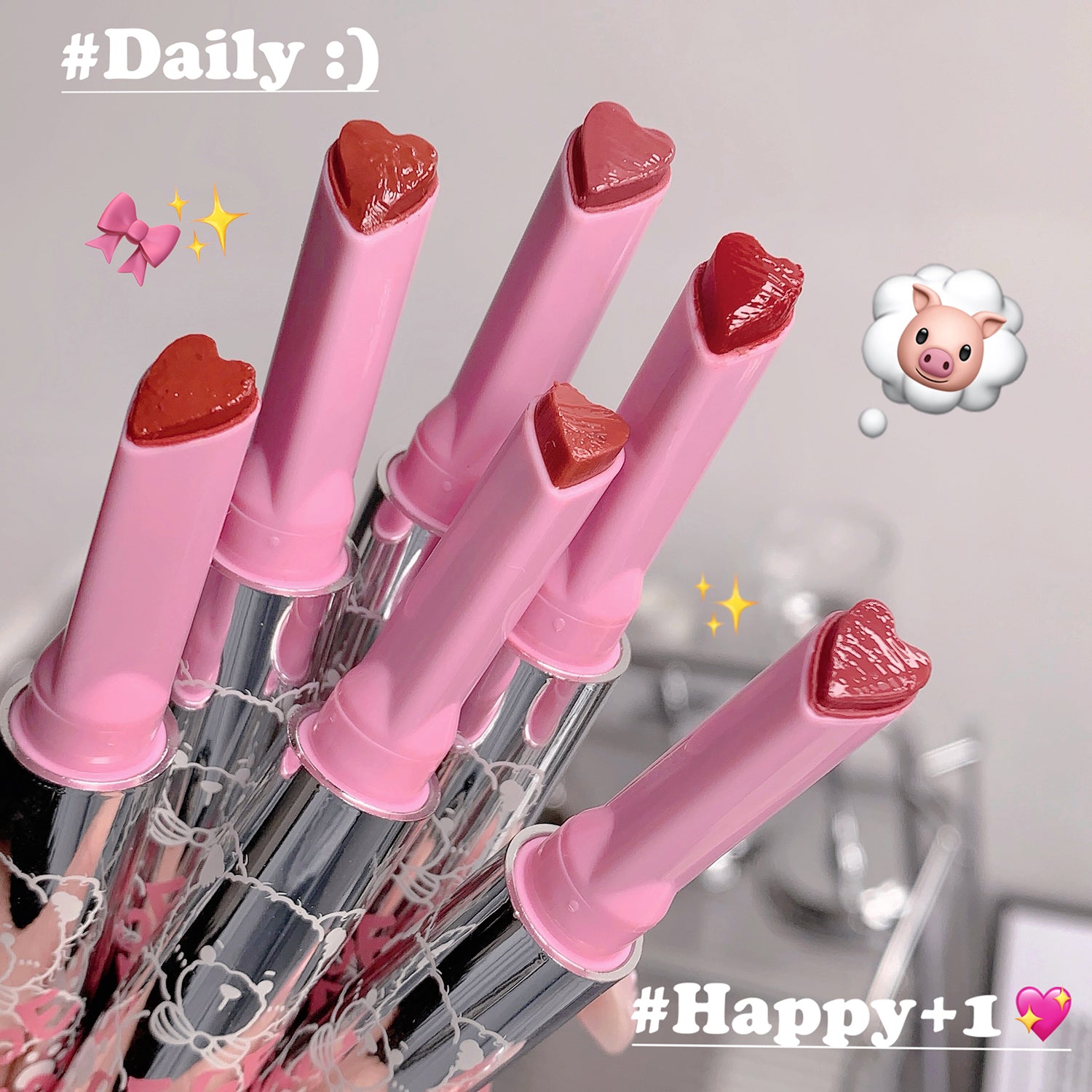 Set of pink lip-shaped pens with red caps on a gray background