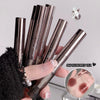 Lipstick applicators held by a hand with a close-up of lipstick application on skin.