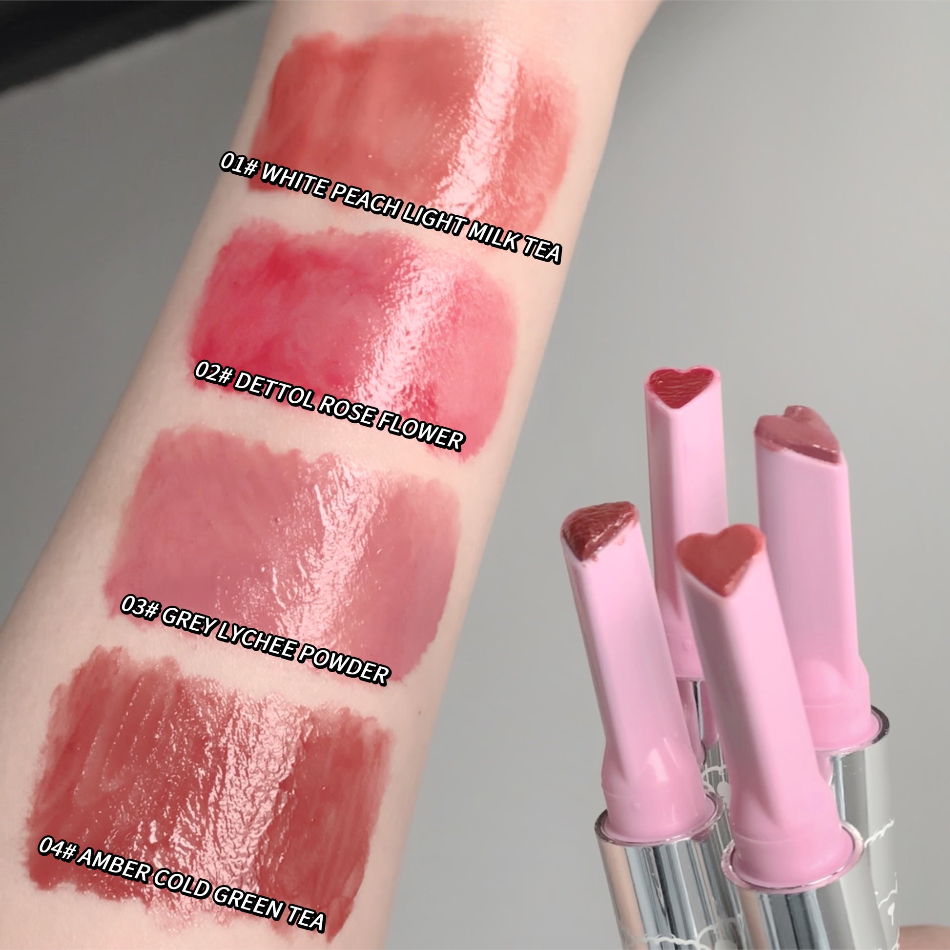 Lipstick swatches on a arm with four different shades and three lipsticks with heart-shaped caps.