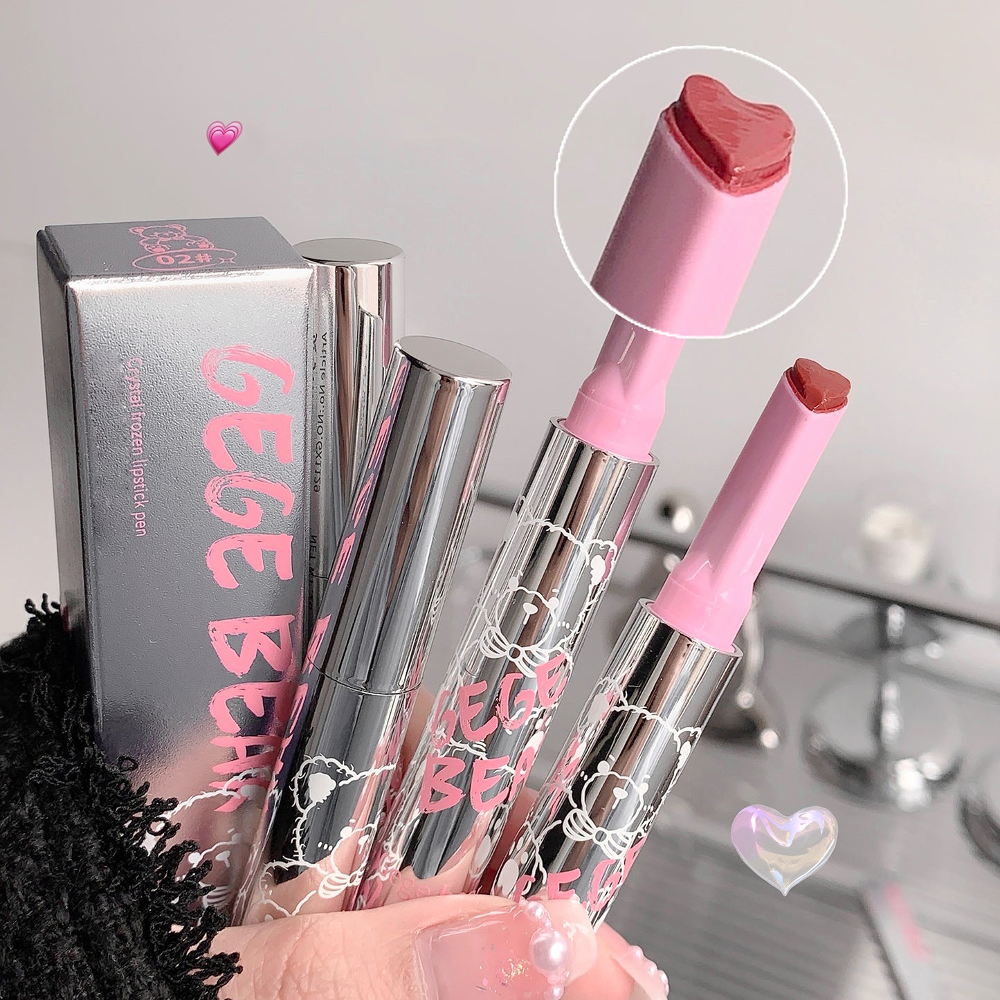 Pink and clear lipsticks with a close-up of the pink lipstick cap, GEGE BEAR packaging in the background.