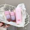 Pink lip balm and its packaging on a white decorative stand.