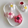 Flower-shaped lip balms with 'Gege Bear' branding on a white dish.