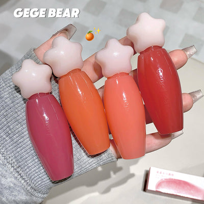 Four star-shaped lip glosses held by a hand with 'GEGE BEAR' branding.