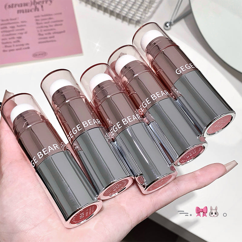 Set of GE GE BEAR lipsticks held in a hand with a blurred background