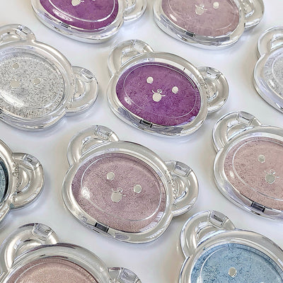 Multiple compact powder cases with various colors on a white background