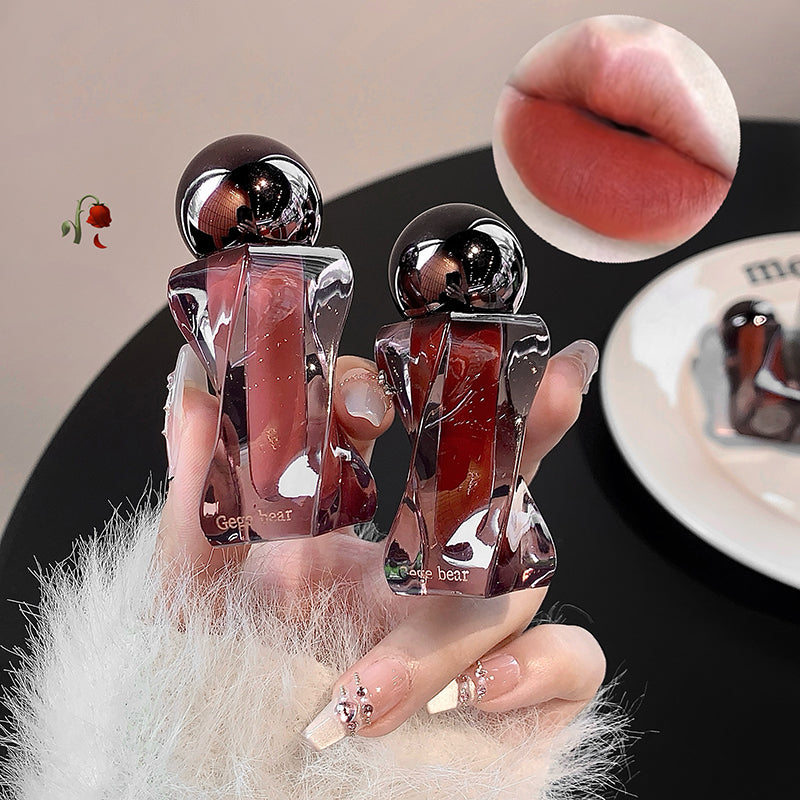 Two lip glosses held by a hand with a close-up of lips wearing the product.
