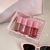 Pink nail polish bottles in a basket with sunglasses on a light background