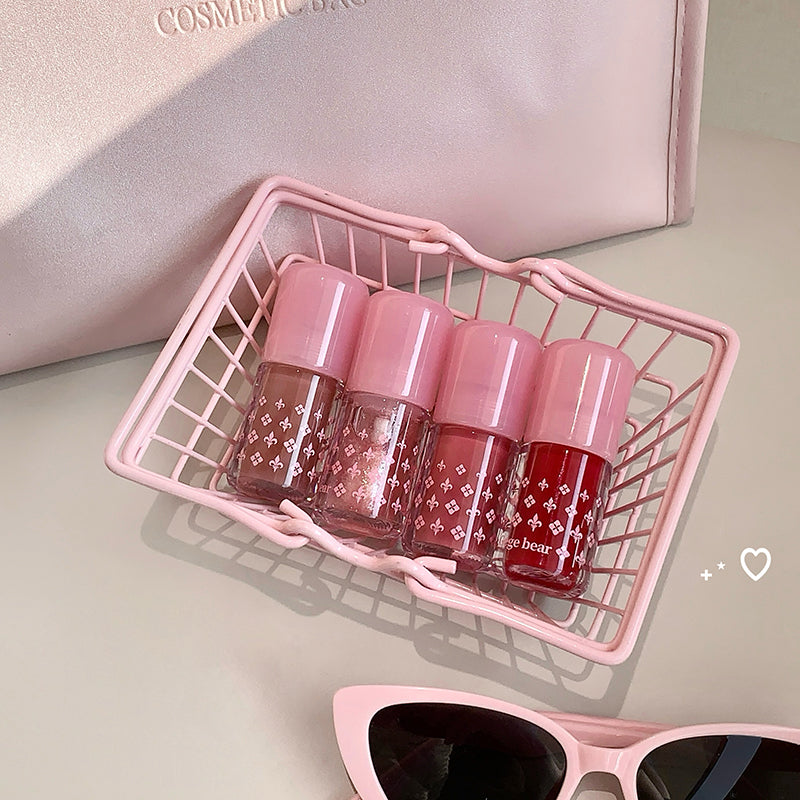 Pink nail polish bottles in a basket with sunglasses on a light background