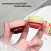 Two Gege bear lip glosses held in a hand with a white background