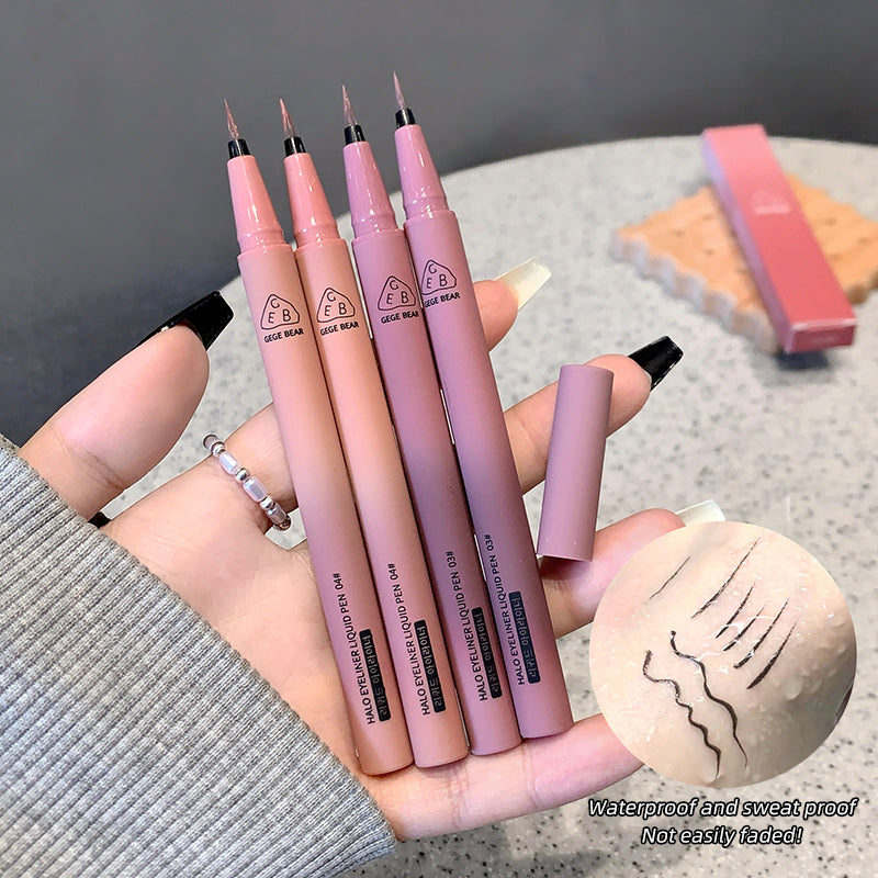 Set of pink makeup pens held by a hand with a blurred background