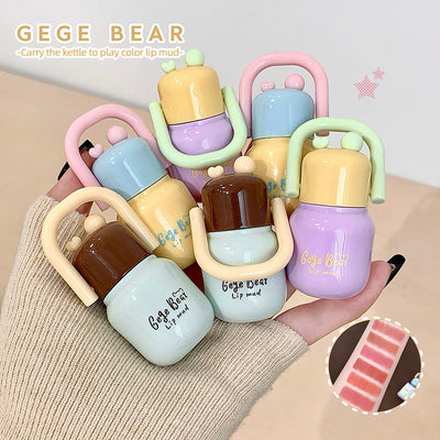 Colorful lip mud products with 'GEGE BEAR' branding on a beige surface.