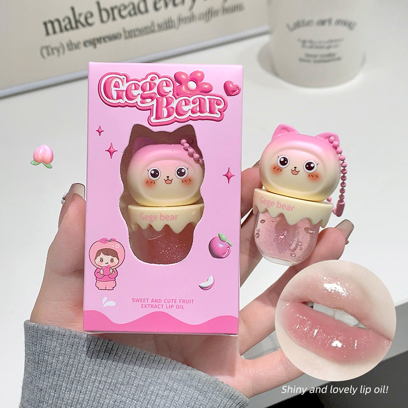 Gege Bear lip oil with packaging and close-up of the product on a blurred background