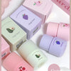 Collection of Gege Bear lip balms and packaging on a light pink background
