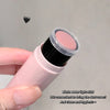 Hand holding a blush water light stick with a clear cover on a gray background