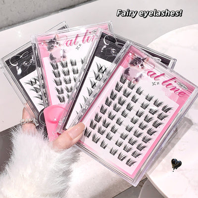 Multiple packages of false eyelashes held by a hand on a light background