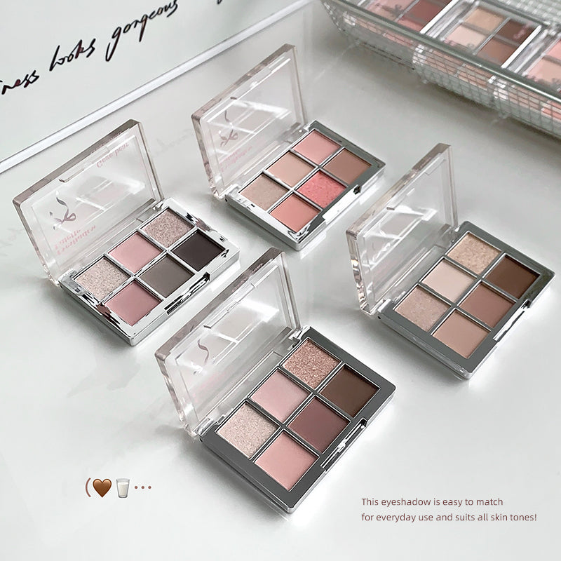 Set of open eyeshadow palettes with a neutral color palette on a light background.