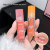 Two lip gloss products held in a hand with a blurred background