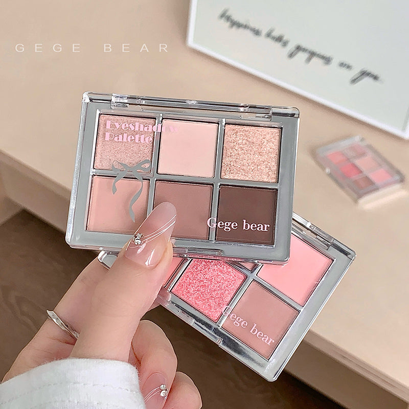 Makeup palette with pink and brown shades held by a hand, brand 'GEGE BEAR' visible.