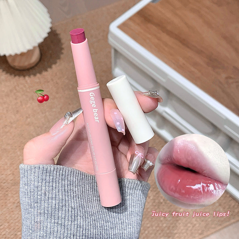 Hand holding a pink lip pen and white lip balm with a blurred background