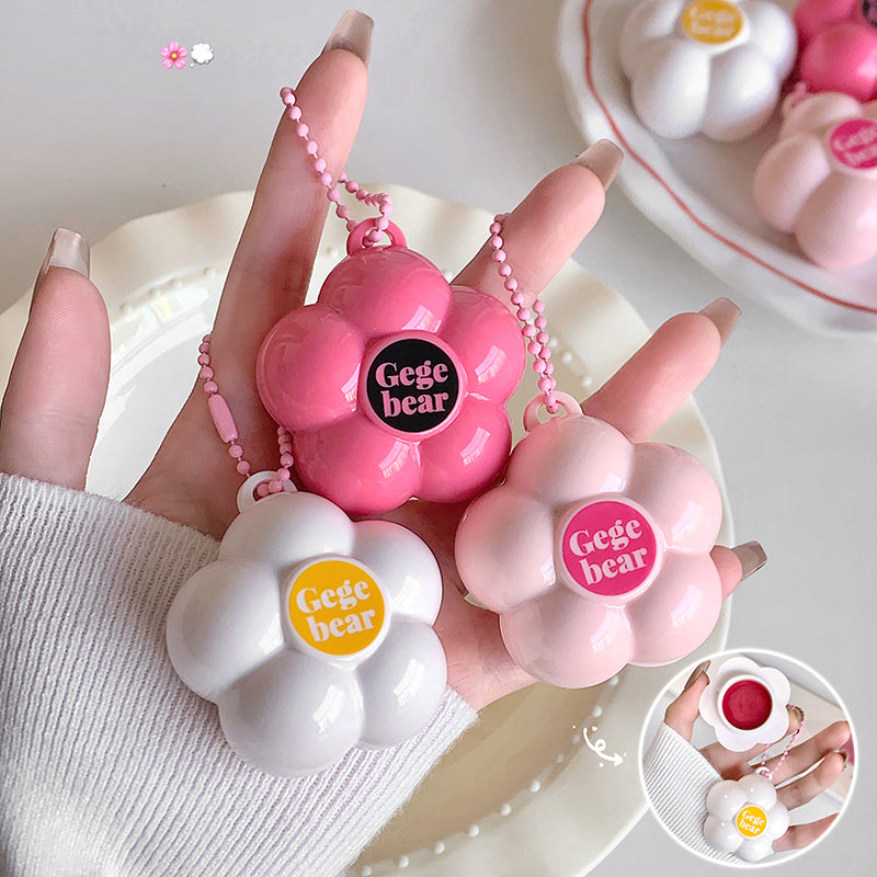 Pink and white 'Gege bear' products held by a hand with a white sleeve.