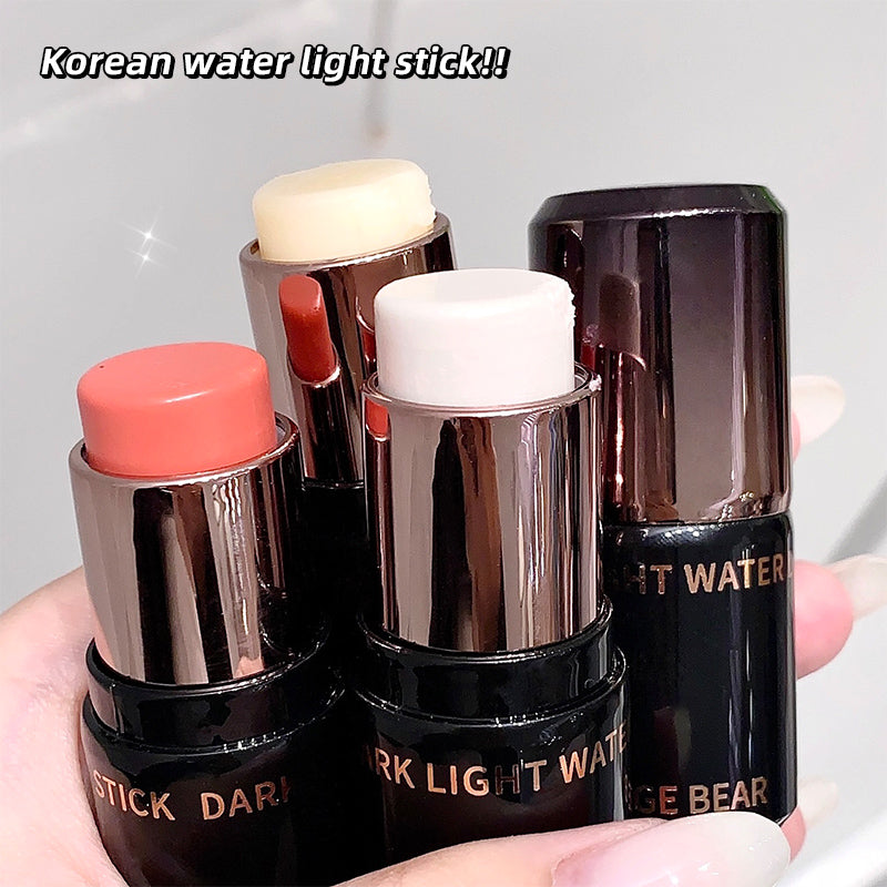 Four Korean water light sticks with different colored caps held by a hand against a neutral background.