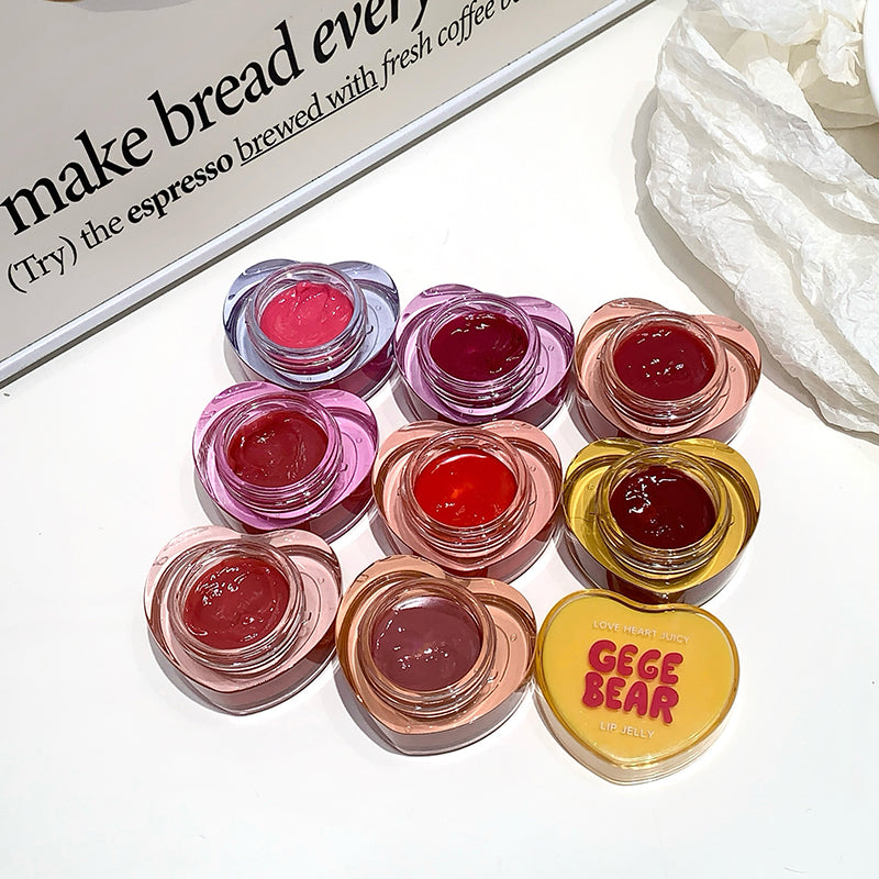 Set of small lip gloss containers with a visible brand label on a white surface.
