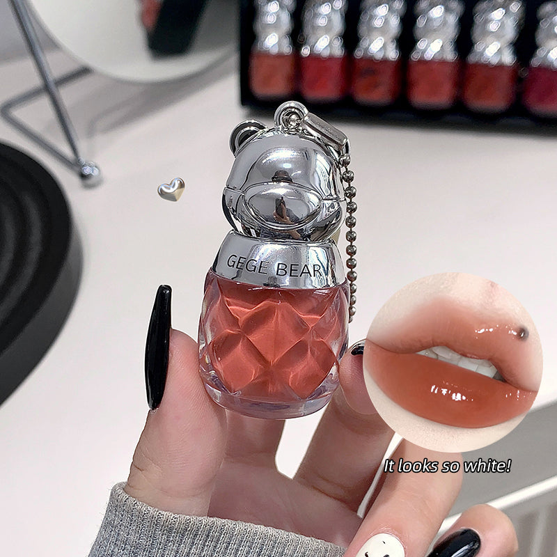 Small bottle with a mirror and 'GeeG Bear' branding, held by a hand with black nail polish.