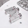 Silver nail art display with tools on a white surface