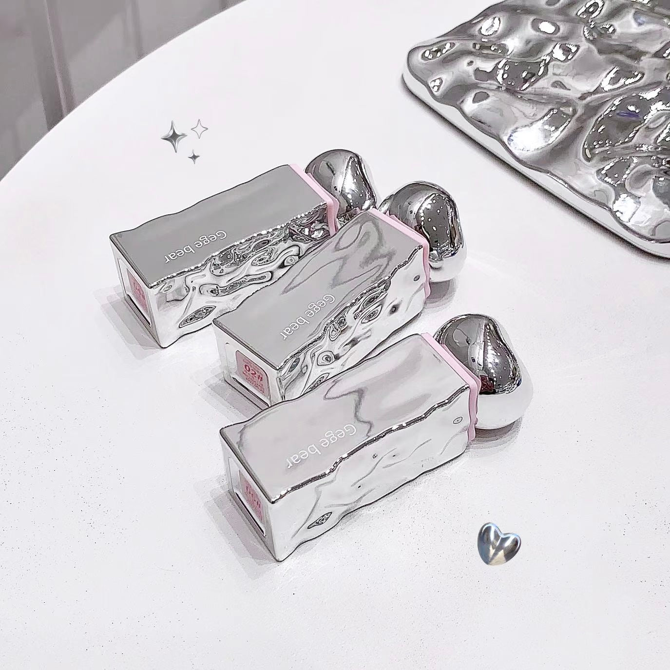 Silver nail art display with tools on a white surface