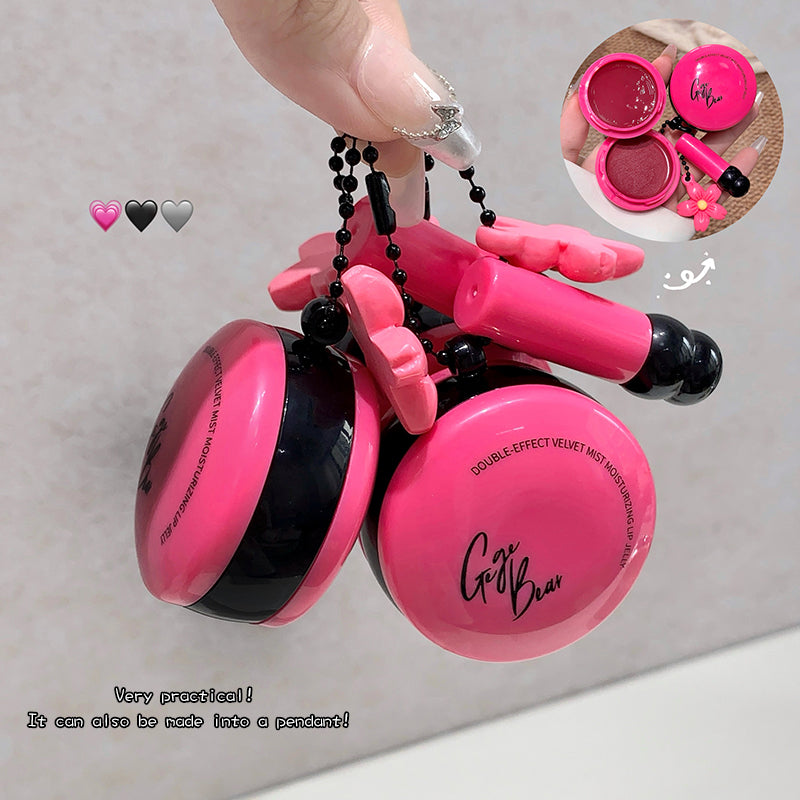 Pink and black makeup compact held by a hand with a gray background