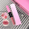 Pink lip gloss with packaging on a striped background