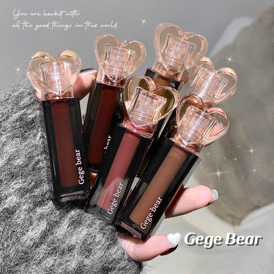 Hand holding multiple Gege Bear lipsticks with a textured surface background