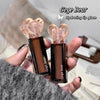 Two Gege Bear hydrating lip glazes held in a hand with a blurred background