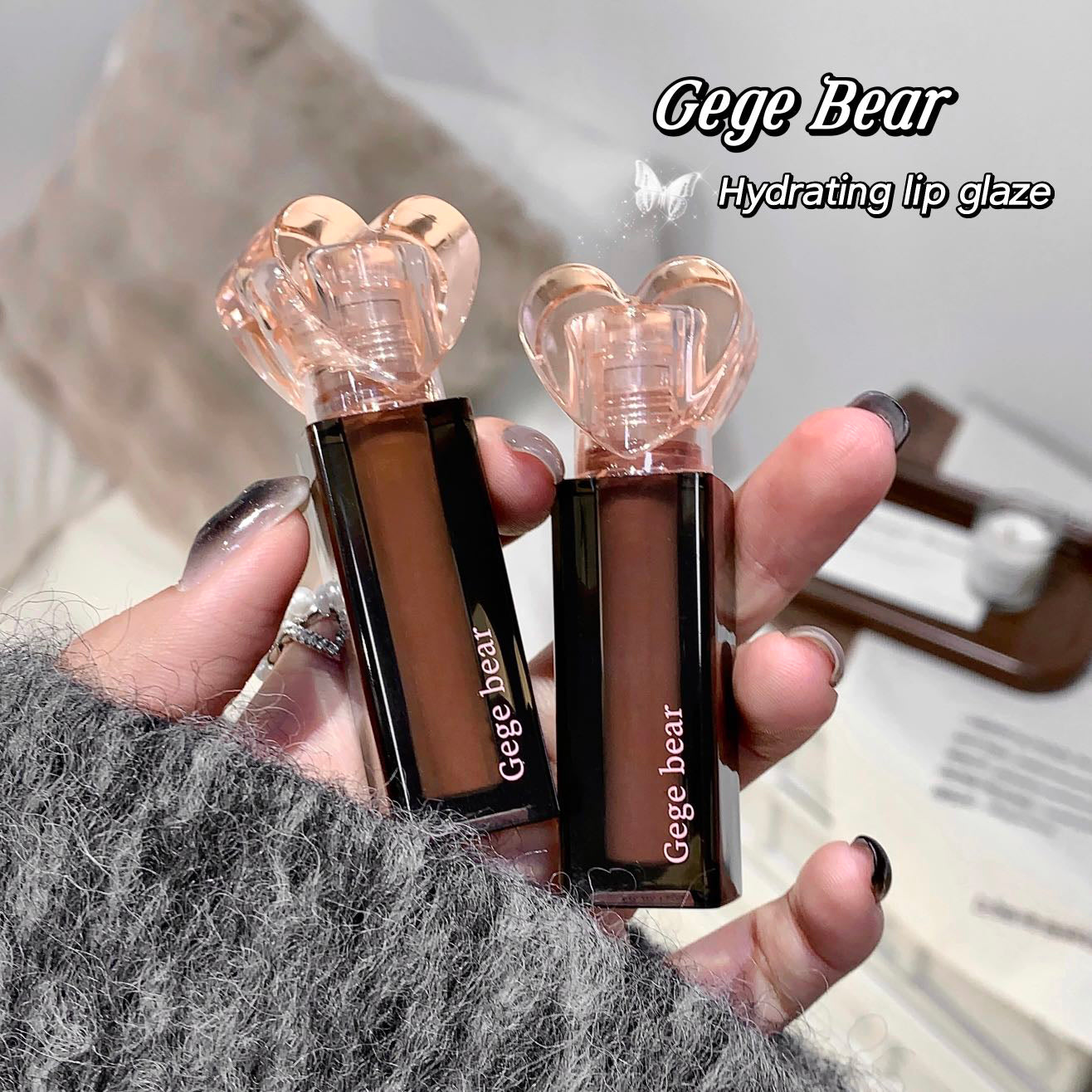 Two Gege Bear hydrating lip glazes held in a hand with a blurred background