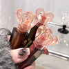 Hand holding a set of lipsticks with rose gold caps against a blurred background