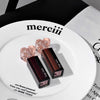 Two lipsticks with heart-shaped caps on a white plate with 'merciii' text.