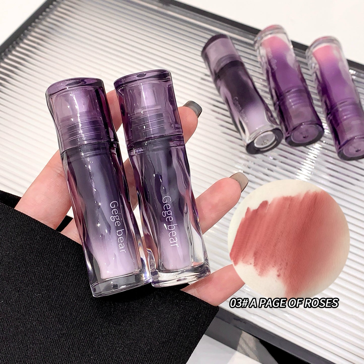 Two purple makeup products held by a hand with a blurred background