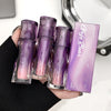 Set of purple makeup products with 'Gene' branding held by a hand against a blurred background.