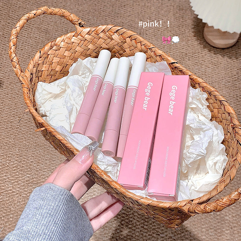 Basket with pink lip products and packaging on a textured surface