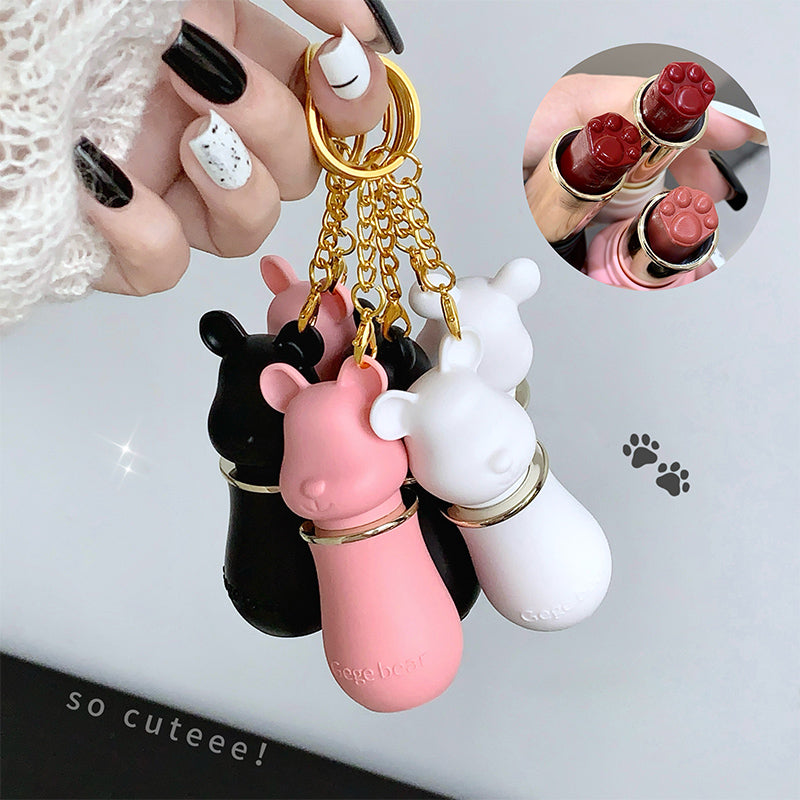Keychain with animal-shaped ends held by a hand, with inset showing close-up of keychain and lipsticks.