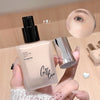 Hand holding a cosmetic bottle labeled 'Gigi Bear' with a close-up of an eye and foundation sample on a wooden surface.