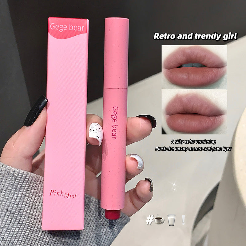 Pink lipstick with packaging held by a hand, showing close-up of lips wearing the lipstick.