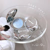Makeup compact with 'Gege bear' branding on a clear stand.