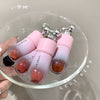 Pink and white lip glosses with a cherry-like texture on a clear dish, branded 'GEGE BEAR'.