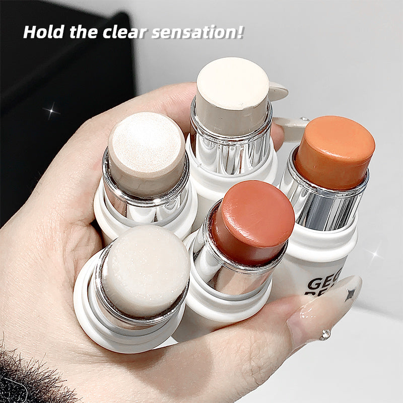 Hand holding multiple cosmetic sticks with visible brand name, against a neutral background.