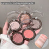 Multiple makeup compact powders held in a hand with a gray background