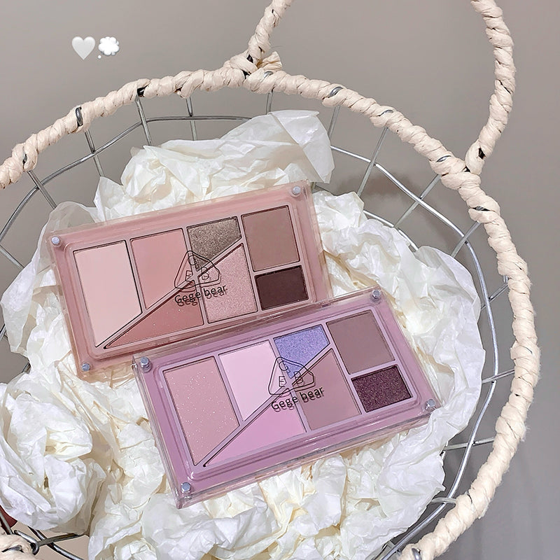 Makeup palette with a pink lid on a white floral background